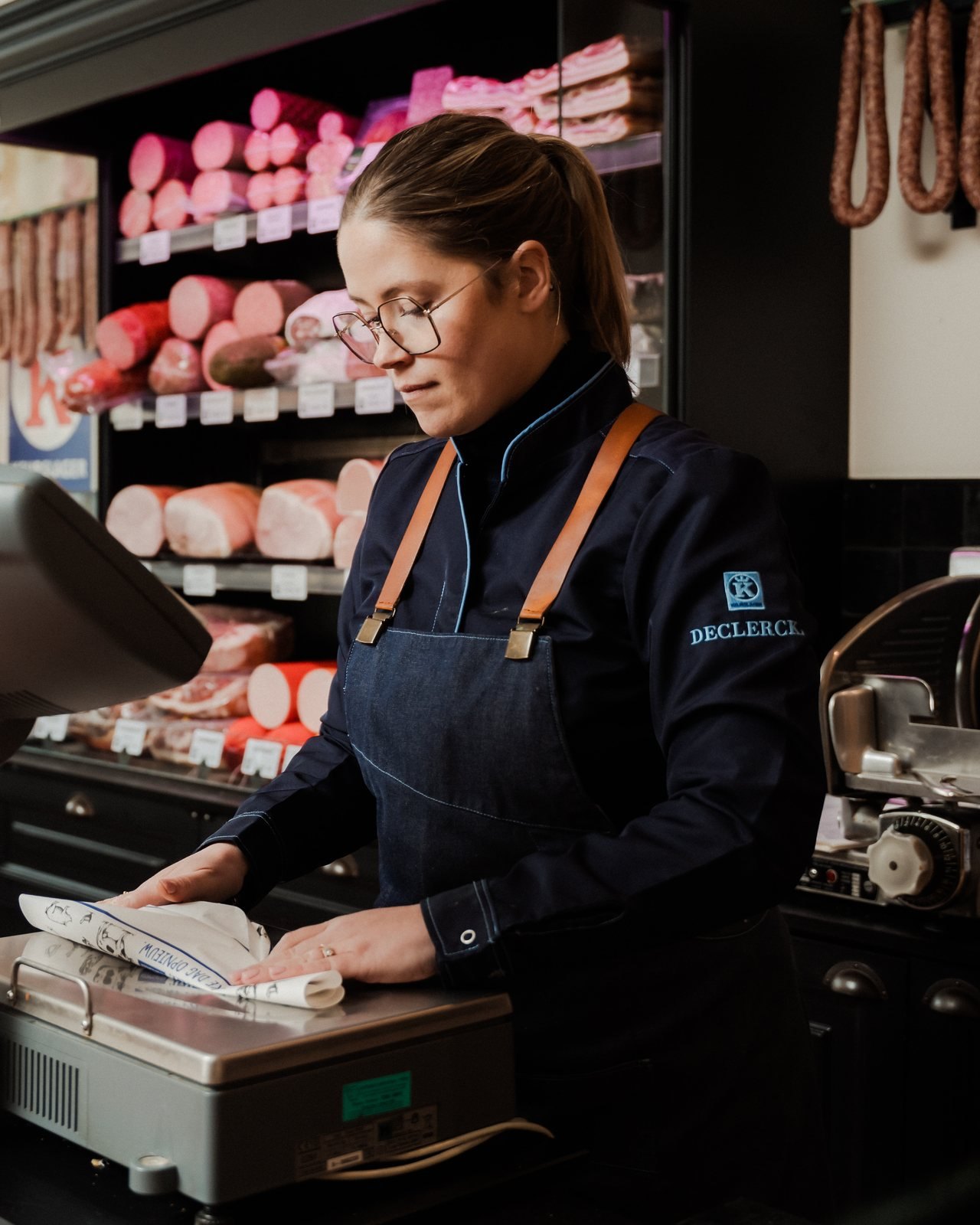 Davina aan de toonbank in de winkel in Kaprijke