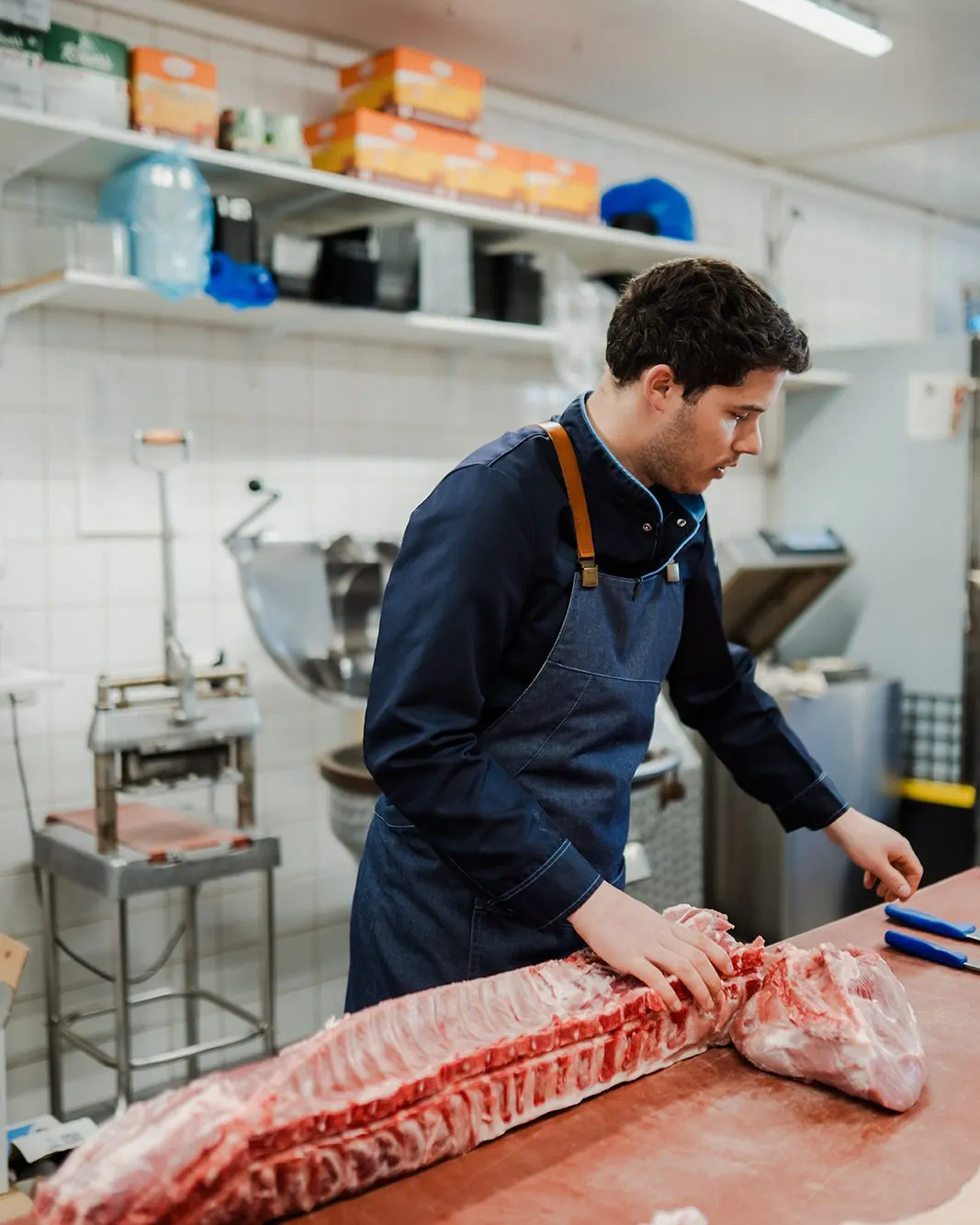 Jean-Baptiste versnijdt vlees in het atelier